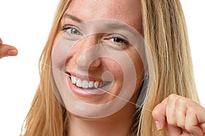 Happy young woman flossing her teeth