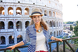 Happy young woman in front of Colosseum in Rome, Italy