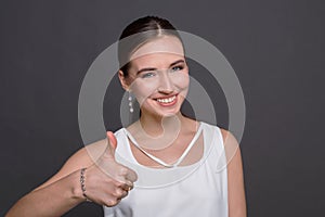 Happy young woman giving thumb up gesture