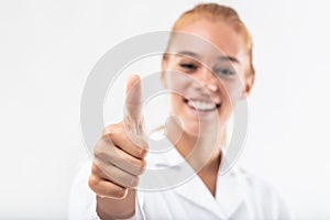 Happy young woman giving a thumbs up gesture