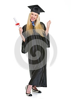 Happy young woman in graduation gown with diploma