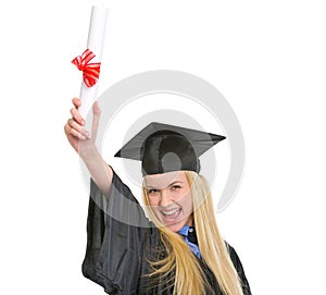 Happy young woman in graduation gown with diploma