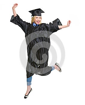 Happy young woman in graduation gown jumping