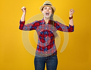 Happy young woman grower on yellow background rejoicing