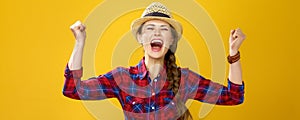 Happy young woman grower on yellow background rejoicing