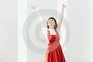 Happy young woman with hands up.  Enjoying life . Freedom. Girl on the light background