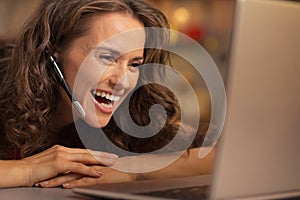 Happy young woman having christmas video chat on laptop