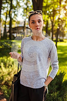 Happy young woman having fun in summer park. Girl playing the ape