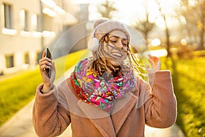 Happy young woman with headphones and cell phone