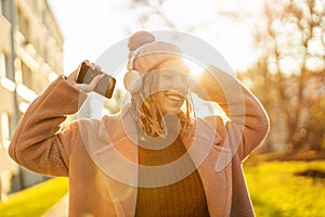 Happy young woman with headphones and cell phone
