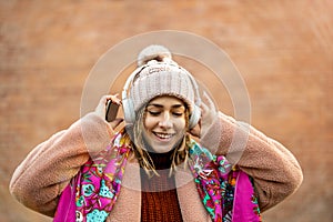 Happy young woman with headphones and cell phone