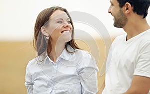 Happy young woman with her man walking together in summer field