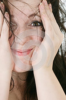 Happy young woman hides her face