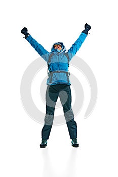 Happy young woman, hiker in jacket, gloves and goggles jumping isolated on white background. Comfortable and necessary