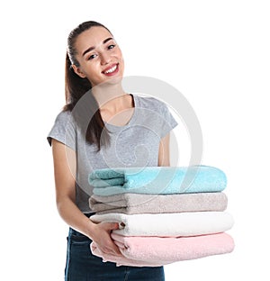 Happy young woman holding clean towels on white background