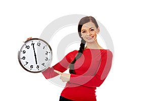 Happy young woman holding clock