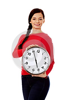 Happy young woman holding clock