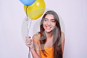 Happy young woman holding colorful balloons