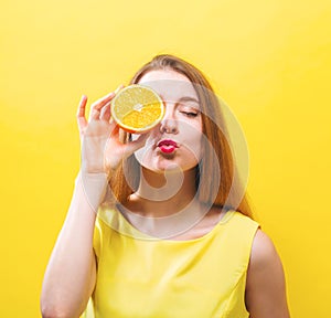 Happy young woman holding a half orange