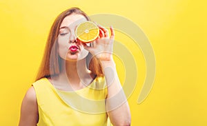 Happy young woman holding a half orange