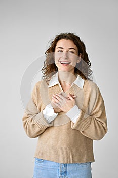 Happy young woman holding hands on chest feeling gratitude and love in heart.