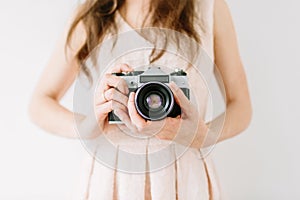 Happy young woman holding in hands old vintage camera. Girl photographer