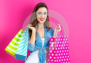 Happy young woman holding many shopping bags