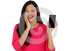 Happy young woman holding mobile photne against whtie photo