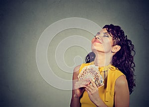 Happy young woman holding money