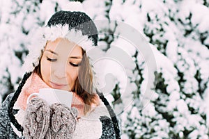 Happy young woman holding mug of tea winter snowy