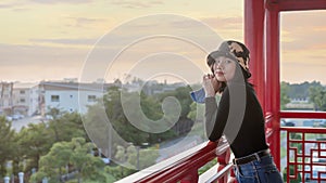 Happy young woman holding protective mask for prevention Covid-19 and relaxing on viewpoint of city