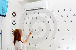 Happy Young Woman Holding Remote Control Relaxing Under The Air Conditioner.