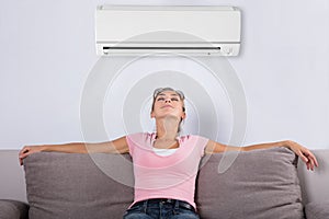 Woman Relaxing Under The Air Conditioner