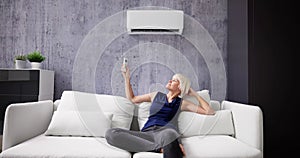 Happy Young Woman Holding Remote Control Relaxing Under The Air