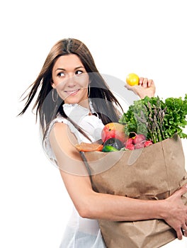 Happy young woman holding a shopping bag full of groceries fruit