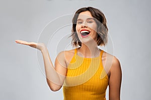 Happy young woman holding something on empty hand