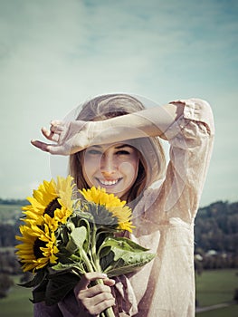 Happy young woman holding sunflowers