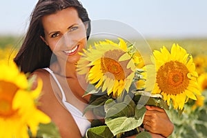 Happy young woman holding sunflowers