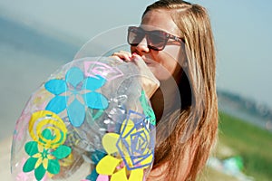 Happy young woman inflating the inflatable ball
