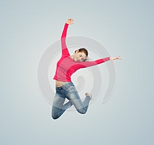 Happy young woman jumping in air or dancing