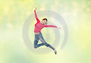 Happy young woman jumping in air or dancing