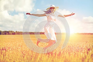 Happy young woman jumping on cereal field