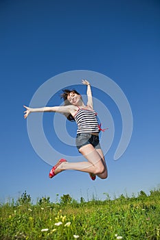 Happy young woman jumping in a field