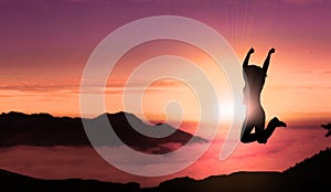 Happy Young Woman Jumping For Joy On The Peak of Mountain Sunset Landscape . Free Successful Female Jumps in Top Mountain