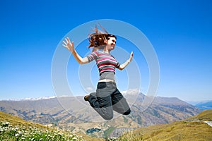 Happy Young woman jumping with Mt Aspiring landscape view in Wanaka, New Zealand