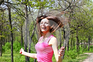 Happy young woman jumping with a skipping rope in a summer park