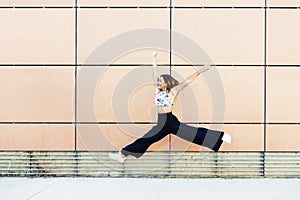 Happy young woman jumping in urban background