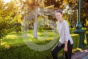 Happy young woman laughing posing in summer park. College student with bag walking and having fun