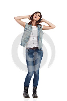 Happy Young Woman Is Listening Music In Headphones And Looking Up