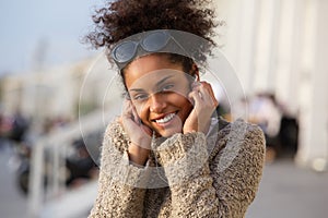 Happy young woman listening to music on headphones outdoors